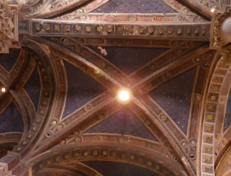 Light at the center of a cross on the ceiling of Siena Cathedral